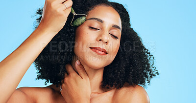 Buy stock photo Studio, beauty and woman with roller for skincare, wellness and dermatology for anti aging benefits. Blue background, facial massage and happy person with tool for healthy skin, cosmetic or self care