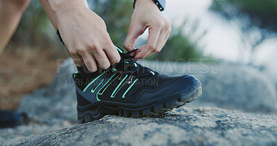 Buy stock photo Person, hands and tying with shoes for hiking adventure, fitness or preparation on rock in nature. Hiker, tourist or getting ready with laces or sneakers for outdoor trekking journey or mountain walk