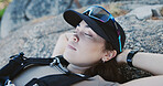 Sleeping, woman and tired of hiking on rocks for endurance challenge, intense trail and break. Hiker burnout, person and exhausted on mountain with resting, trekking fatigue and recovery in nature