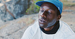 Break, breathing and black man on mountain for hiking, exercise or health in nature for fitness. Fatigue, active and African person with rest for trekking outdoor with challenge and wellness.