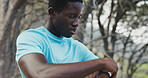 Fitness, tired and man with smart watch outdoor to check cardio pace, monitor heart rate and sweat. Athlete, black person and workout timer in nature for sports performance, recovery time and resting
