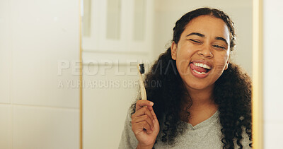 Buy stock photo Mirror, toothbrush and woman in bathroom with wink for dental hygiene, oral wellness and natural. Bamboo, tongue out and happy person brushing teeth, eco friendly or cleaning with reflection in house