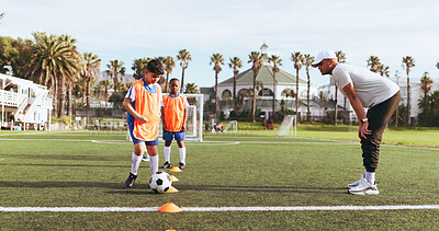 Buy stock photo Coach, kids and soccer ball for drills on field for sports, practice and help with game. Man, children and football training for exercise, cardio and skills with cones for dribbling on outdoor pitch