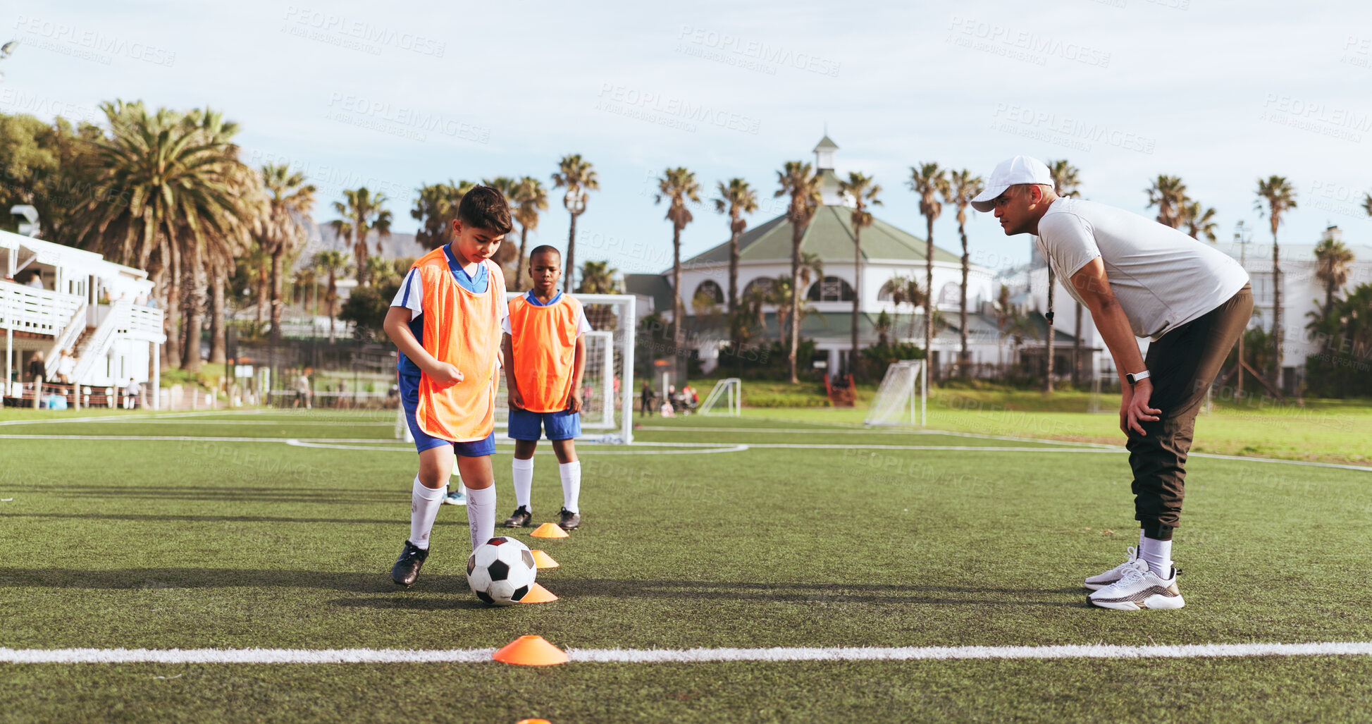 Buy stock photo Coach, kids and soccer ball for drills on field for sports, practice and help with game. Man, children and football training for exercise, cardio and skills with cones for dribbling on outdoor pitch