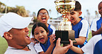 Excited, coach and kids with trophy on field, soccer tournament success and celebration victory. Football team, winning match award or happy children with man for achievement, competition or cheering