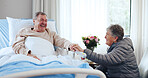 Laugh, old couple and holding hands in hospital for support, funny conversation and visit for comfort. Smile, care and senior people with humor in medical clinic, talking and flowers for recovery