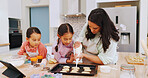 Mom, help and baking with children in kitchen, development and cookie decoration with icing in home. Teaching, kids and recipe for dessert preparation, bonding and woman with frosting in house