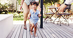 Walking, excited and toddler with family outdoor on patio for learning, milestone and support. Happy, love and connection with child and parents in backyard of home for growth, steps and development 