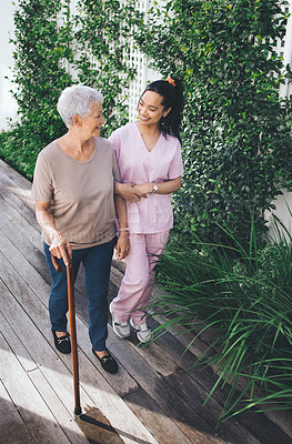 Buy stock photo Outdoor, walking stick and nurse with old woman for talking, wellness and fresh air for health. Nursing home, above and caregiver with elderly person with cane for balance, conversation and help