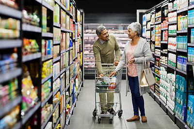 Buy stock photo Shot of a elderly couple grocery shopping in a supermarket