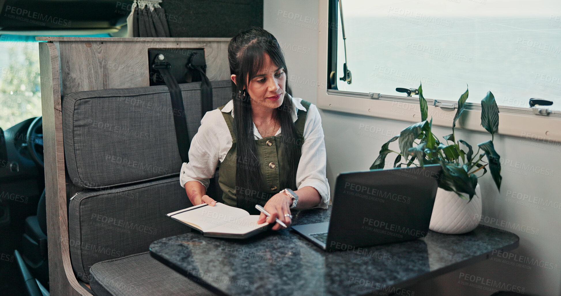 Buy stock photo Digital nomad, notes and woman with laptop in van for project, writer or research for fiction trends. Vehicle, remote work and mature person with journal for ideas, reading and plan story with tech