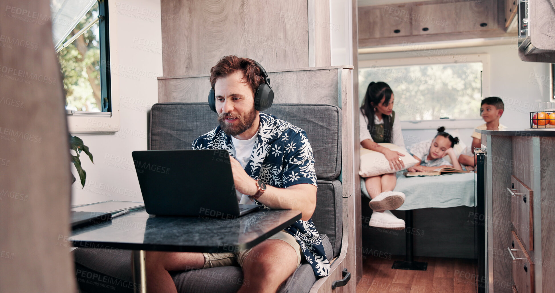 Buy stock photo Laptop, headphones and man in camper van with family for travel blog, copywriting and remote work. Freelance, computer and person with music for tourist guide, research and internet for nomad living