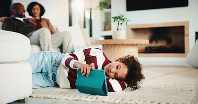Buy stock photo Child, student and relax with tablet at house for research, reading ebook and education video. Parents, daughter and digital for elearning, browsing website and academic games for knowledge in lounge