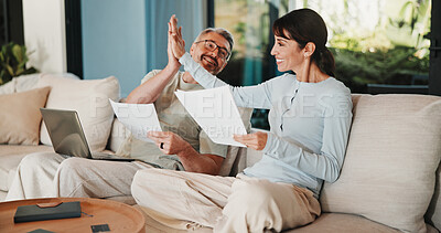 Buy stock photo Couple, documents and high five with taxes in home with revenue increase, success or goals in lounge. Mature people, paperwork and excited with financial review, investment and profit in living room