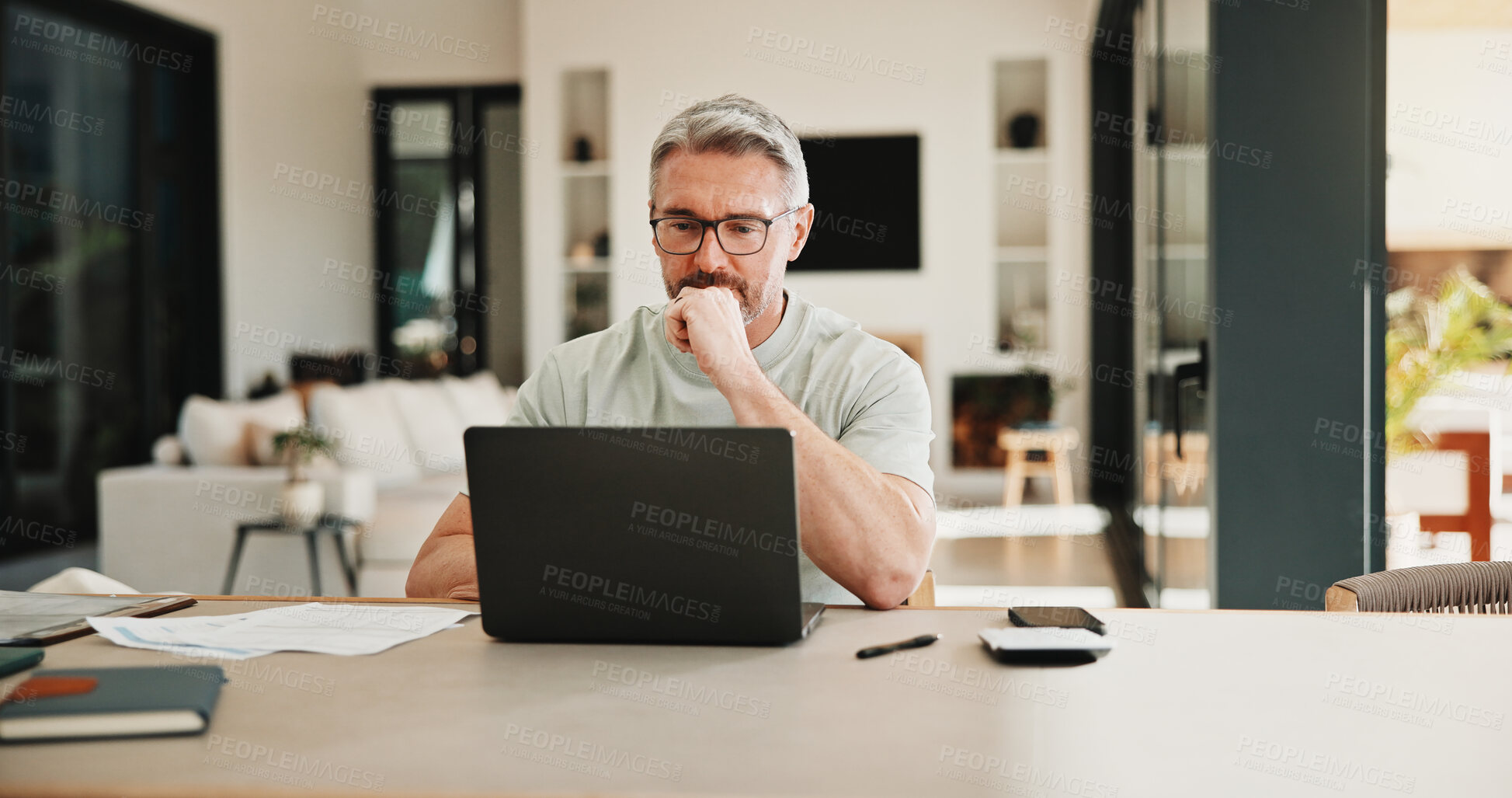 Buy stock photo Man, laptop and stress for paperwork with finance, worry and notes with glasses for budget in home. Mature person, insight and thinking with admin, debt and report for asset management at apartment