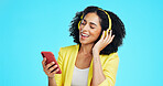 Headphones, sing and businesswoman with phone in studio for music, album or radio on mobile app. Happy, tech and person with cellphone for playlist on streaming subscription by blue background.
