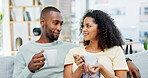 Coffee, happy and couple on sofa in home with talking, bonding or conversation together in living room. Relax, warm beverage and man with woman for connection in relationship at apartment on weekend.