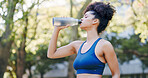 Fitness, woman and drinking water for thirst at park with cardio break, runner nutrition and health. Athlete, person and cold beverage in nature for exercise electrolytes, hydration and healthy detox
