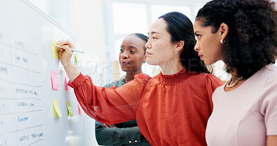 Buy stock photo Women, writing and whiteboard with sticky notes for planning, project strategy or tasks in office. Creative, female people or employees with team ideas for company schedule, agenda or brainstorming