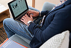Businessman using laptop computer sitting on sofa in office