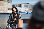 Muslim woman posing for photo smiling happy wearing hijab headscarf in waterfront harbour