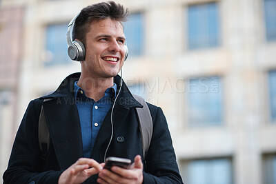 Buy stock photo Happy man, headphones and listening with phone in city for music, travel or outdoor commute. Male person, traveler or smile with smartphone for mobile audio streaming, podcast or sound app in town