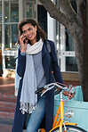 Travel woman with bicycle using smartphone talking on mobile phone in city