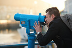 Tourist man using telescope looking at view observing seaside
