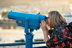 Tourist woman using telescope looking at view observing seaside