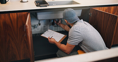 Buy stock photo Plumber, man and inspection in kitchen with clipboard, repair pipe and technician for quality assurance. Back, person and handyman in house with plumbing checklist, evaluation and home maintenance.
