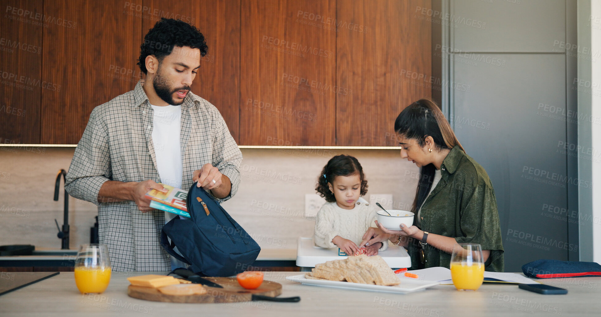 Buy stock photo Family, breakfast and bag with toddler in kitchen for morning routine or back to school preparation. Mom, child and dad packing food with books or meal prep for early childhood development in home