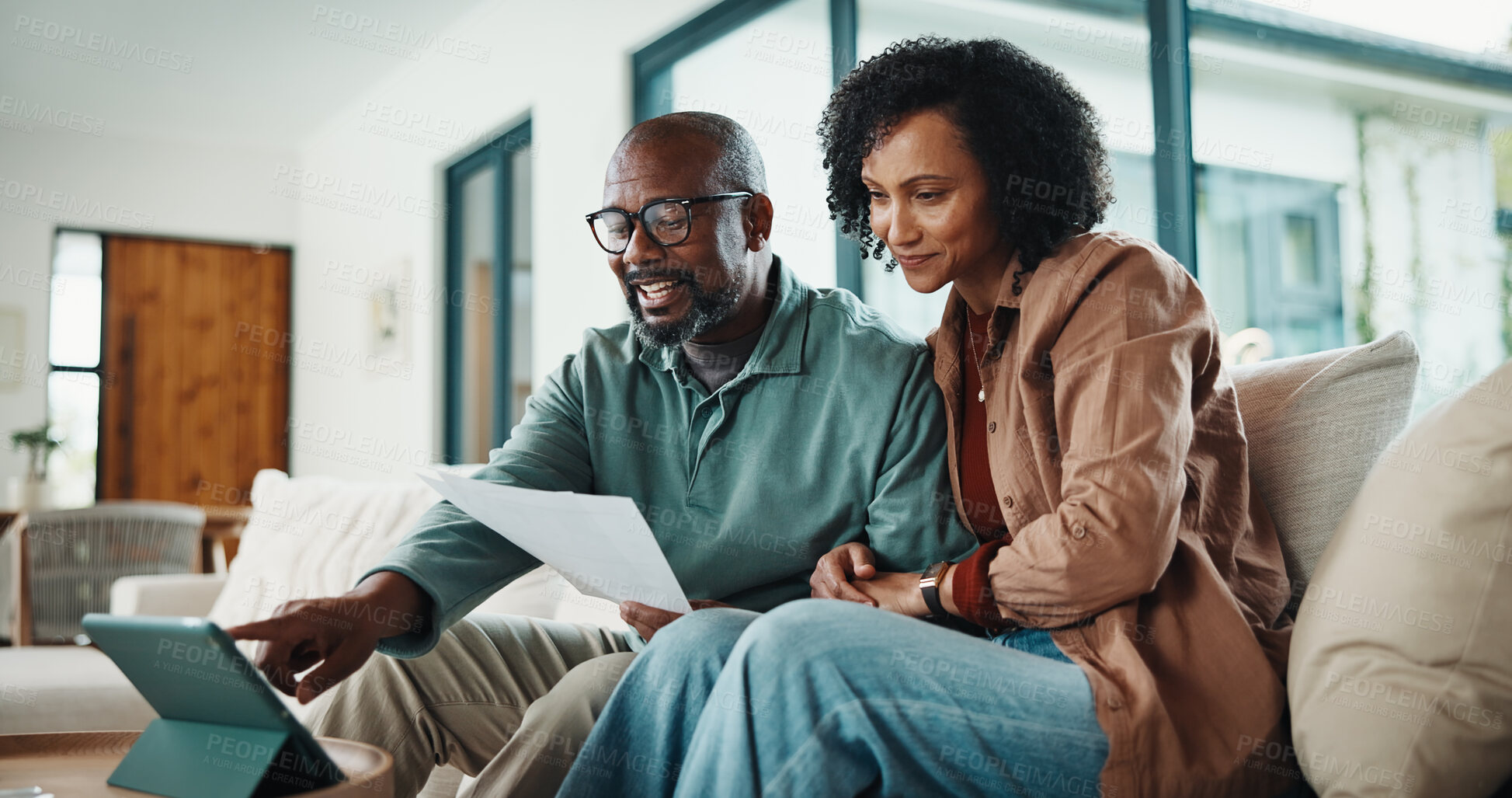 Buy stock photo Document, home and couple with tablet, insurance or pointing for tax review in living room. African man, mature woman and finance on sofa, policy paperwork or smile with tech for debt discussion