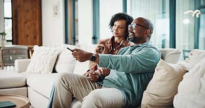 Buy stock photo Couple, remote and watching tv on couch, home and bonding with partner on weekend or streaming movie. Mature African people, love and connection with spouse, smile and change channel with controller