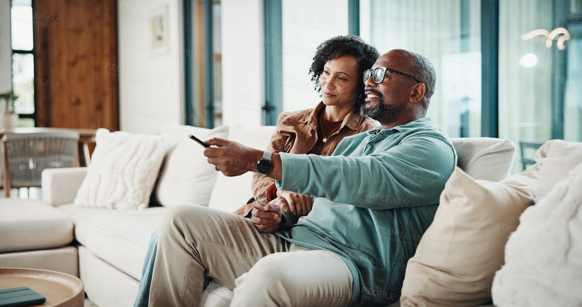 Buy stock photo Couple, remote and watching tv on couch, home and bonding with partner on weekend or streaming movie. Mature African people, love and connection with spouse, smile and change channel with controller