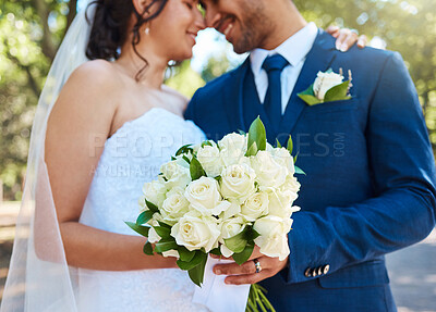 Buy stock photo Couple, wedding and hands with flowers at park for celebration, hug and embrace in spring. Happy people, marriage and bouquet with commitment, connection together or love for relationship at garden