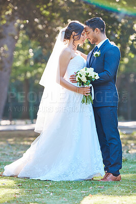 Buy stock photo Happy couple, wedding and hug at park with love, touch forehead and floral bouquet in spring. People, marriage and smile with commitment, flowers or care with embrace for milestone at urban garden