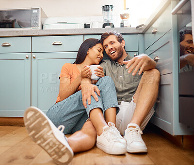 Buy stock photo Couple, happy and relax with drink in kitchen with conversation, bonding and interracial relationship. Cuddle, talking and man with woman on floor for break, commitment and trust with coffee in home