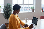 African american business woman using laptop computer working in home office wearing yellow jersey