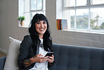Beautiful woman smiling using smartphone sitting on sofa at home