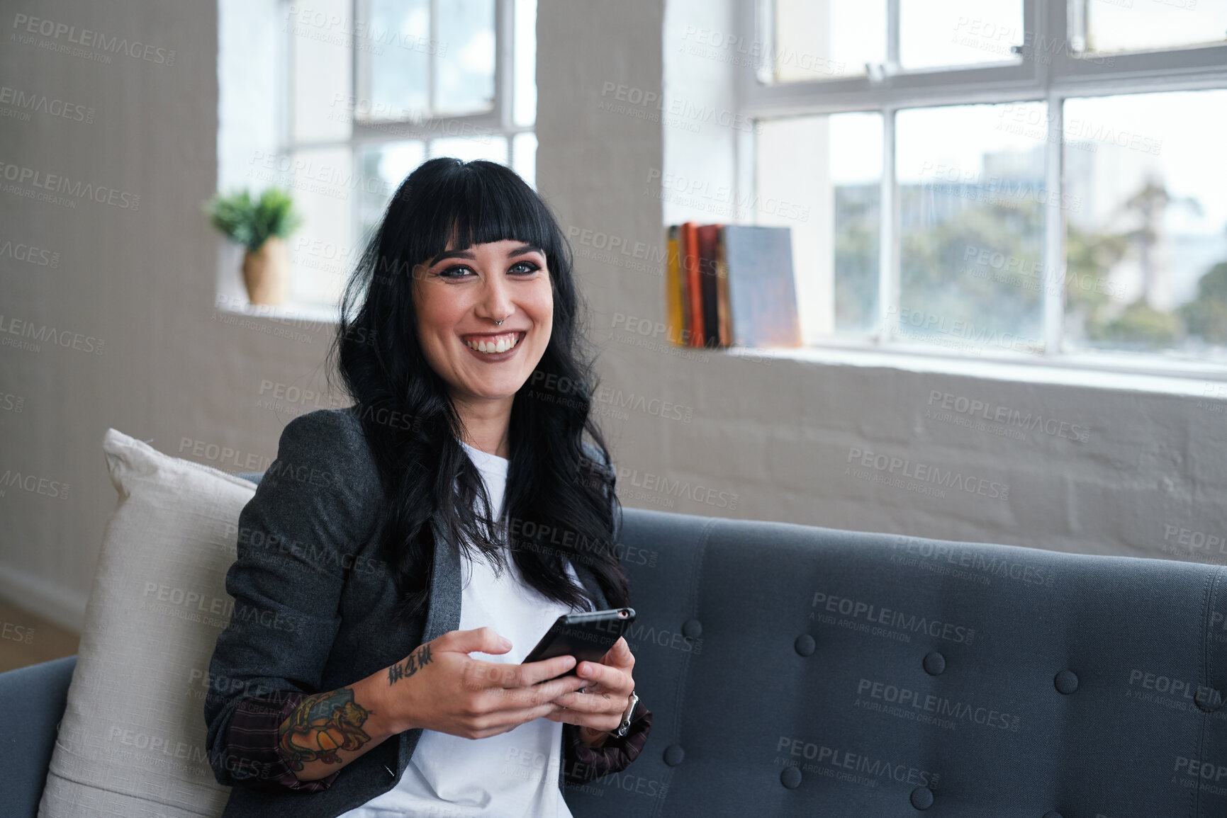 Buy stock photo Phone, relax and portrait of woman in office with texting, networking or social media on mobile app. Happy, technology and female designer on sofa with cellphone for chatting online at startup agency