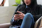 Woman using smartphone texting browsing messages on mobile phone relaxing at home