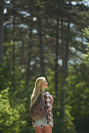 Traveler girl walking alone forest countryside road on wanderlust adventure vacation
