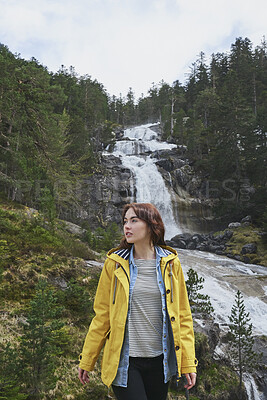Buy stock photo Woman, hiking or sightseeing in nature with waterfall, exploration or outdoor adventure for winter trip. Female person, thinking and peace in forest with scenic view, cold climate or travel vacation.