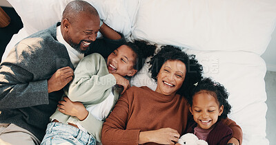 Buy stock photo Relax, cuddle and parents with children in bed, laughing and support for relationship development. Portrait, African family and happy people with girls for connection, bonding and security in home
