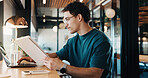 Man, tablet and remote work in restaurant with laptop, online research and editing for graphic design. Freelancer, person and digital designer in cafe with tech, review project or trend for campaign.