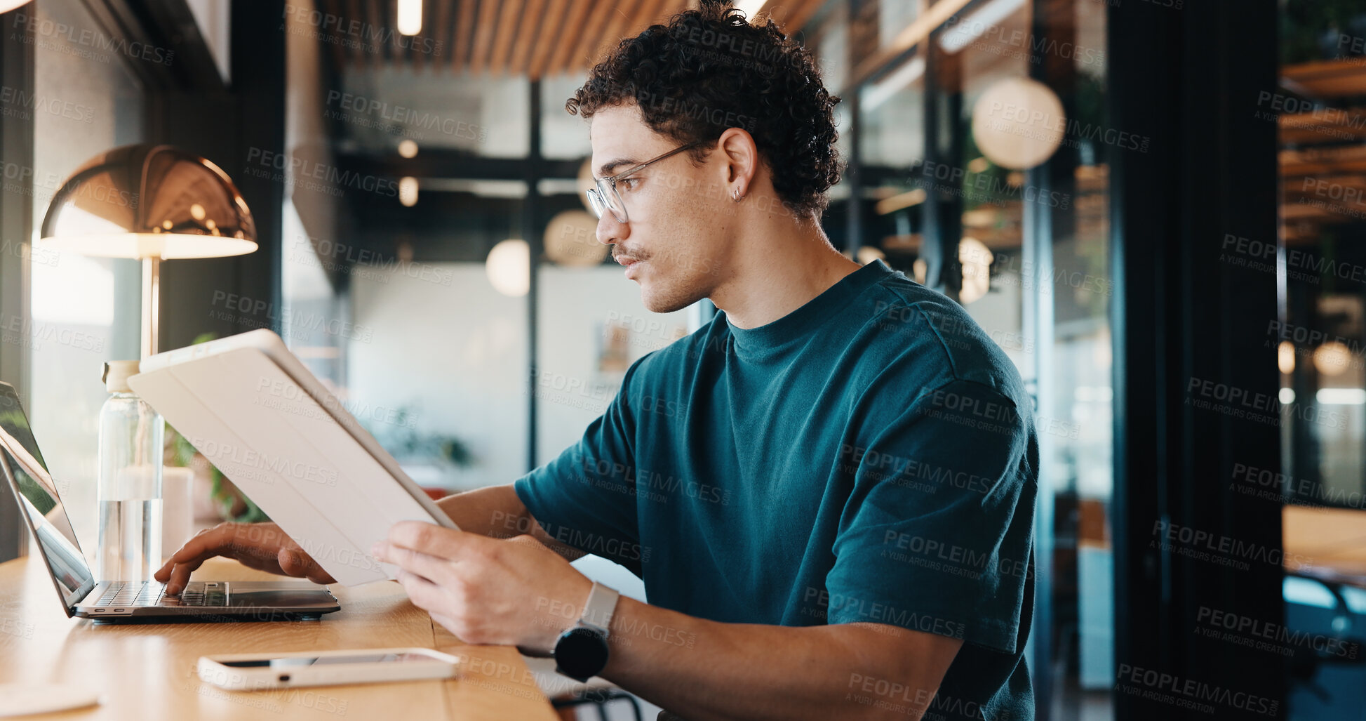 Buy stock photo Man, tablet and remote work in restaurant with laptop, online research and editing for graphic design. Freelancer, person and digital designer in cafe with tech, review project or trend for campaign.