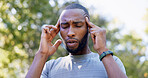 Fitness, runner and black man with headache in nature for pressure, strain and brain fog for health. Sports, exercise and person with head pain for challenge, active hobby and training outdoor