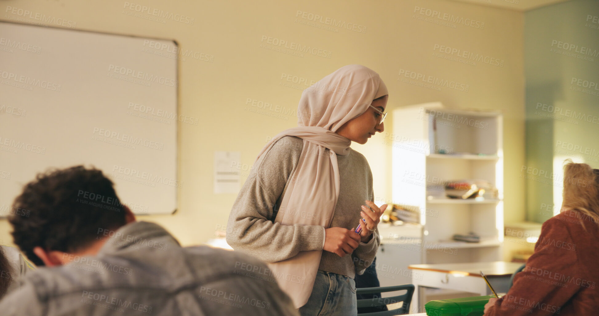 Buy stock photo Teacher, muslim woman and students in class for exam, test supervision and course evaluation. Teaching, progress and islamic educator at high school for learning guidance, assessment and monitor quiz