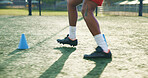 Legs, soccer and person with cone for sports, game practice and running drills for training. Football player, feet and man with equipment on field for agile exercise, fitness challenge and outdoor