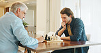 Senior father, son and chess in home with strategy, solution or problem solving in contest for weekend. Family, boardgame and bonding with competition for thinking, knowledge or challenge in house